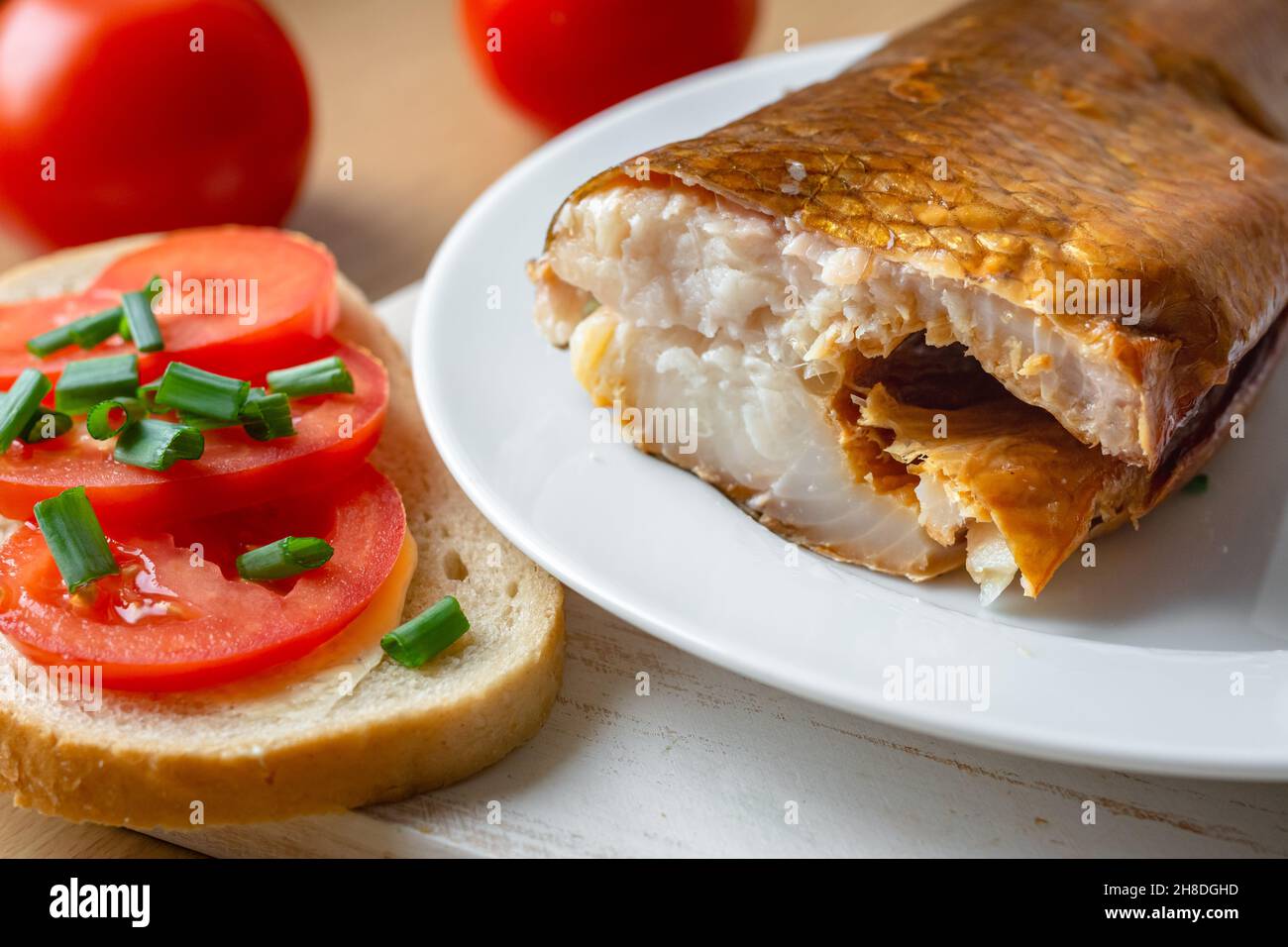 Geräucherter Weißfisch auf einem Teller mit Tomaten-Sandwich Stockfoto