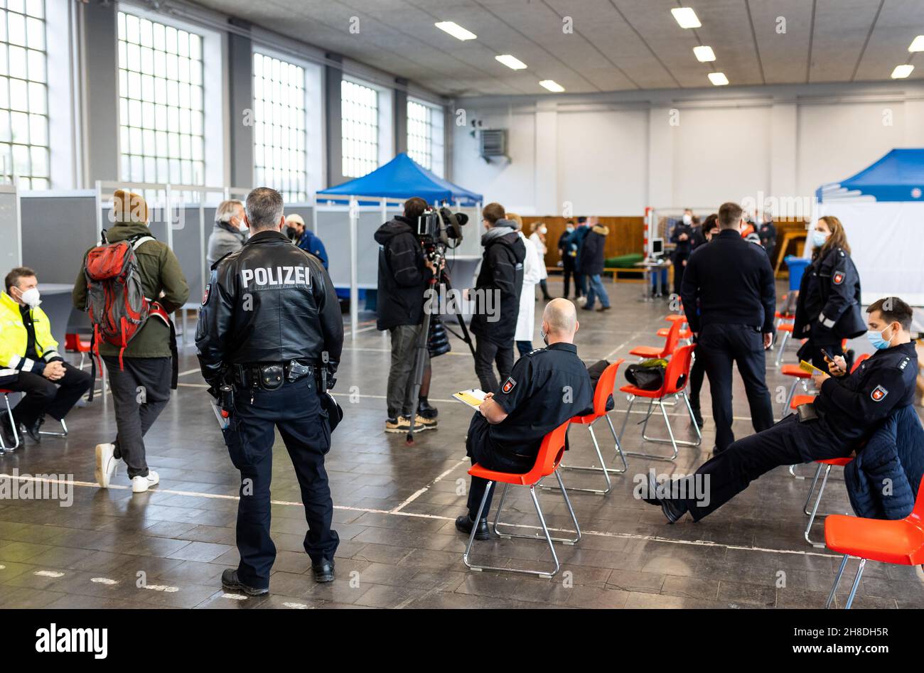 Hannover, Deutschland. 29th. November 2021. Polizeibeamte warten vor Impfkabinen in einer Halle auf dem Gelände der Niedersächsischen Zentralpolizei auf ihre Auffrischungsimpfung gegen Covid-19. Heute beginnt in Hannover eine konzertierte Kampagne zur Erneuerung des Impfstatus für niedersächsische Polizeibeamte. Quelle: Moritz Frankenberg/dpa/Alamy Live News Stockfoto