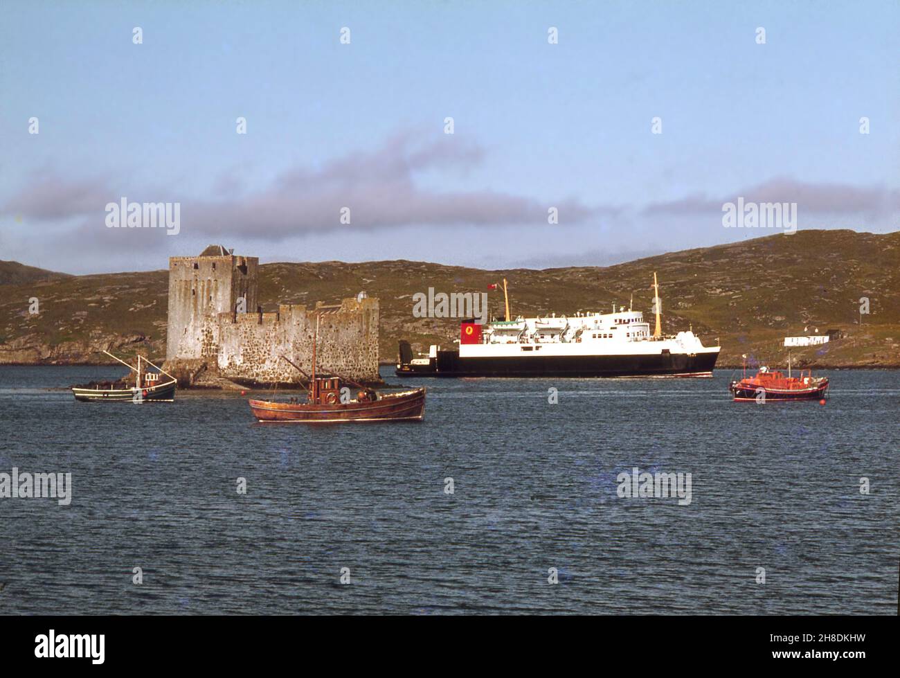 Die MV Iona in castlebay mit der Burg Kisimul im Blick, Isle of Barra 1970s Stockfoto