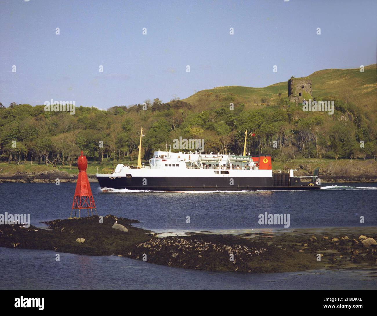 Die MV Iona fährt am Dunollie Castle vorbei, als sie aus Oban Bay 1970s auffährt Stockfoto