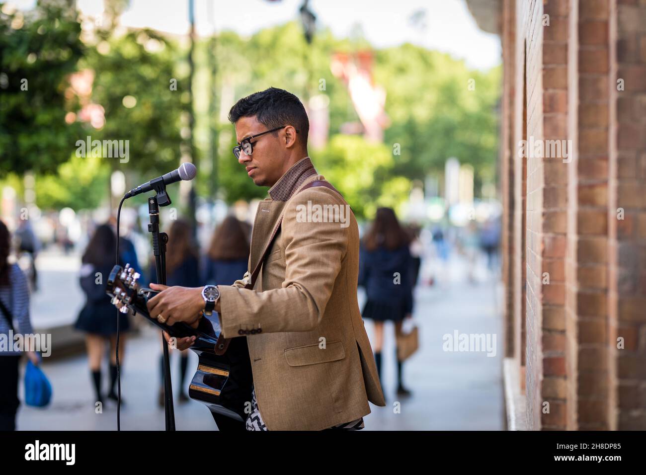 Busker bereitet seine Gitarre vor, bevor er auf der Straße spielt Stockfoto