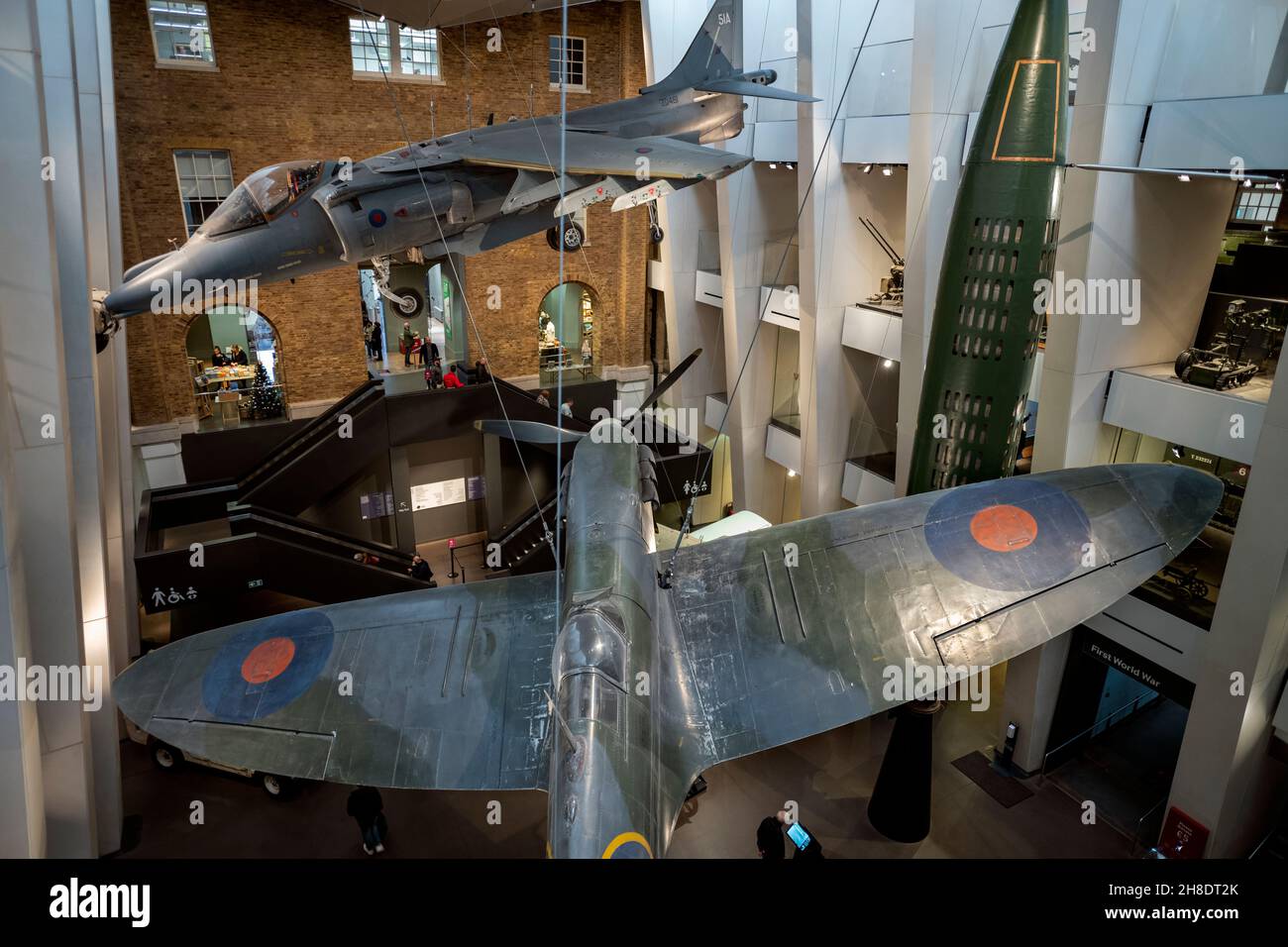 Imperial war Museum Lambeth London Großbritannien England November 2021 das Haupteingang Atrium zeigt einen Harrier ‘Jump’ Jet, eine Spitfire, die in der Schlacht flog Stockfoto