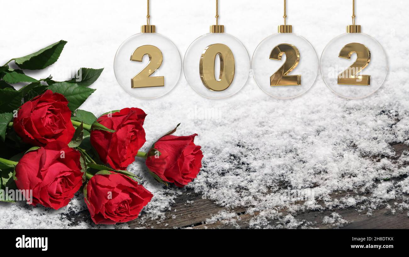 Frohes neues Jahr golden 2022 Ziffern in transparenter Glaskugel mit roten Rosen auf Schnee und Holzziegel darunter Stockfoto