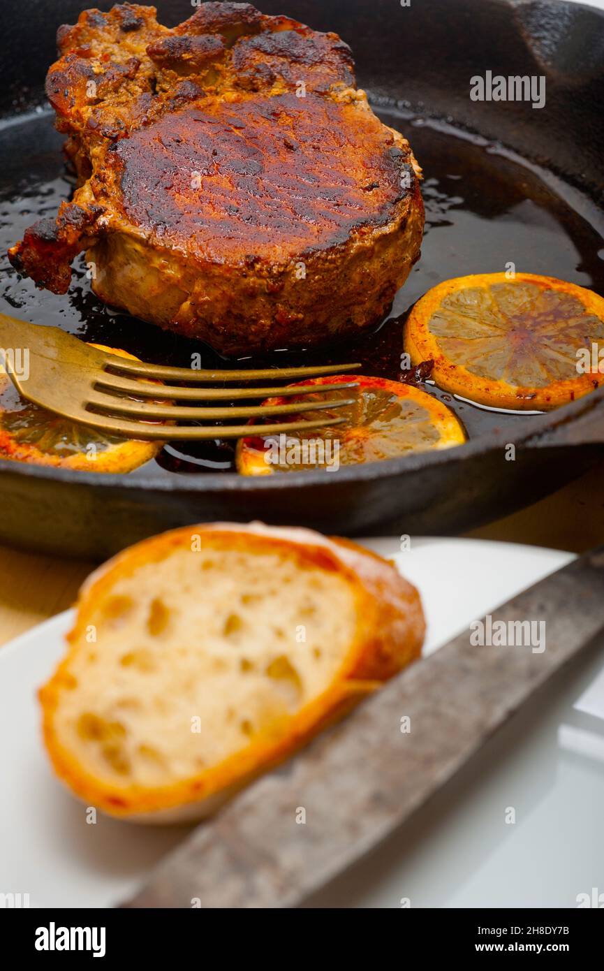 Schweinekotelett auf eisernen Pfanne mit Zitrone und Gewürze Gewürz angebraten Stockfoto