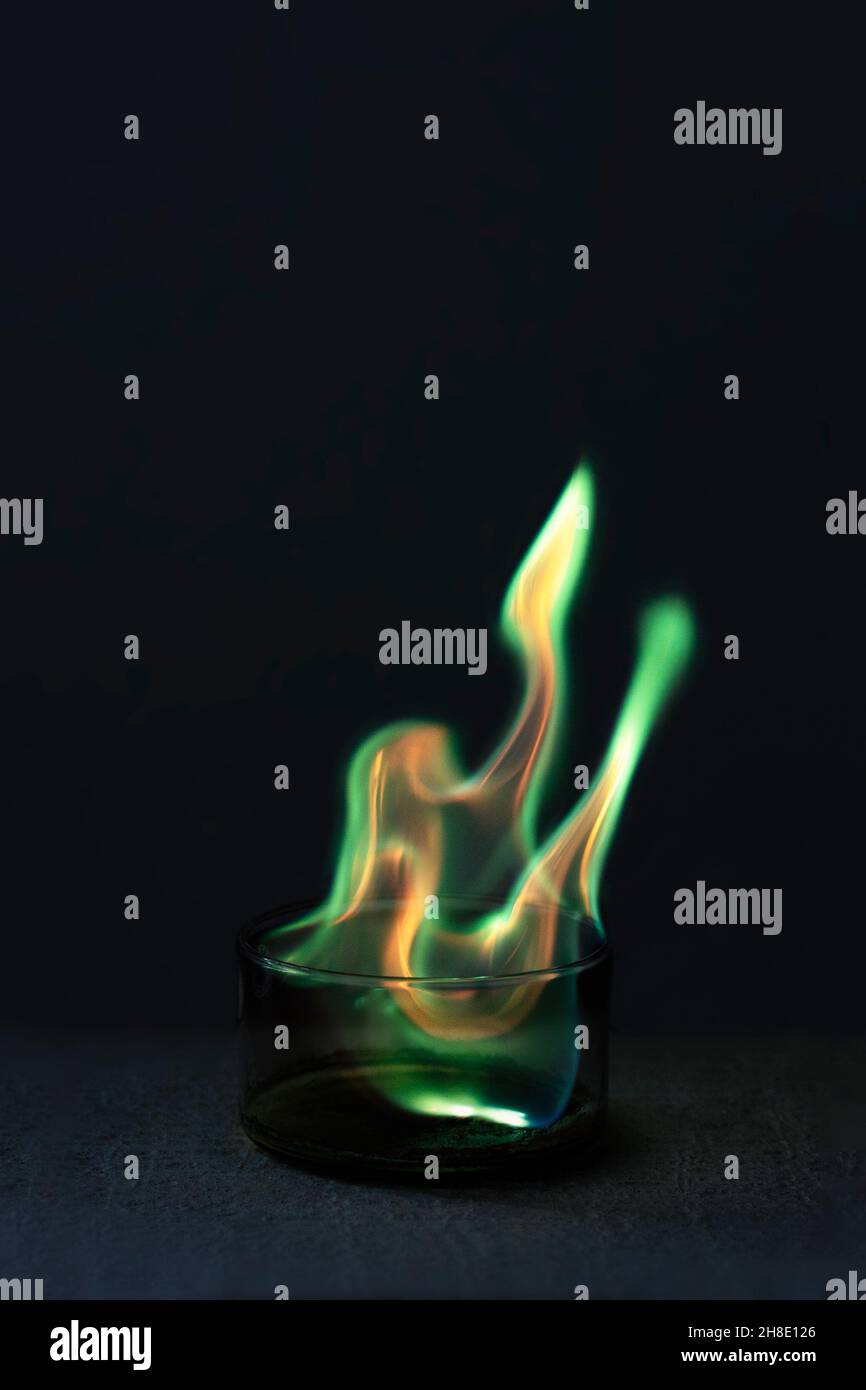 Grüne Flamme, die durch das Verbrennen von Kupferchlorid in einer Glasschale entsteht Stockfoto