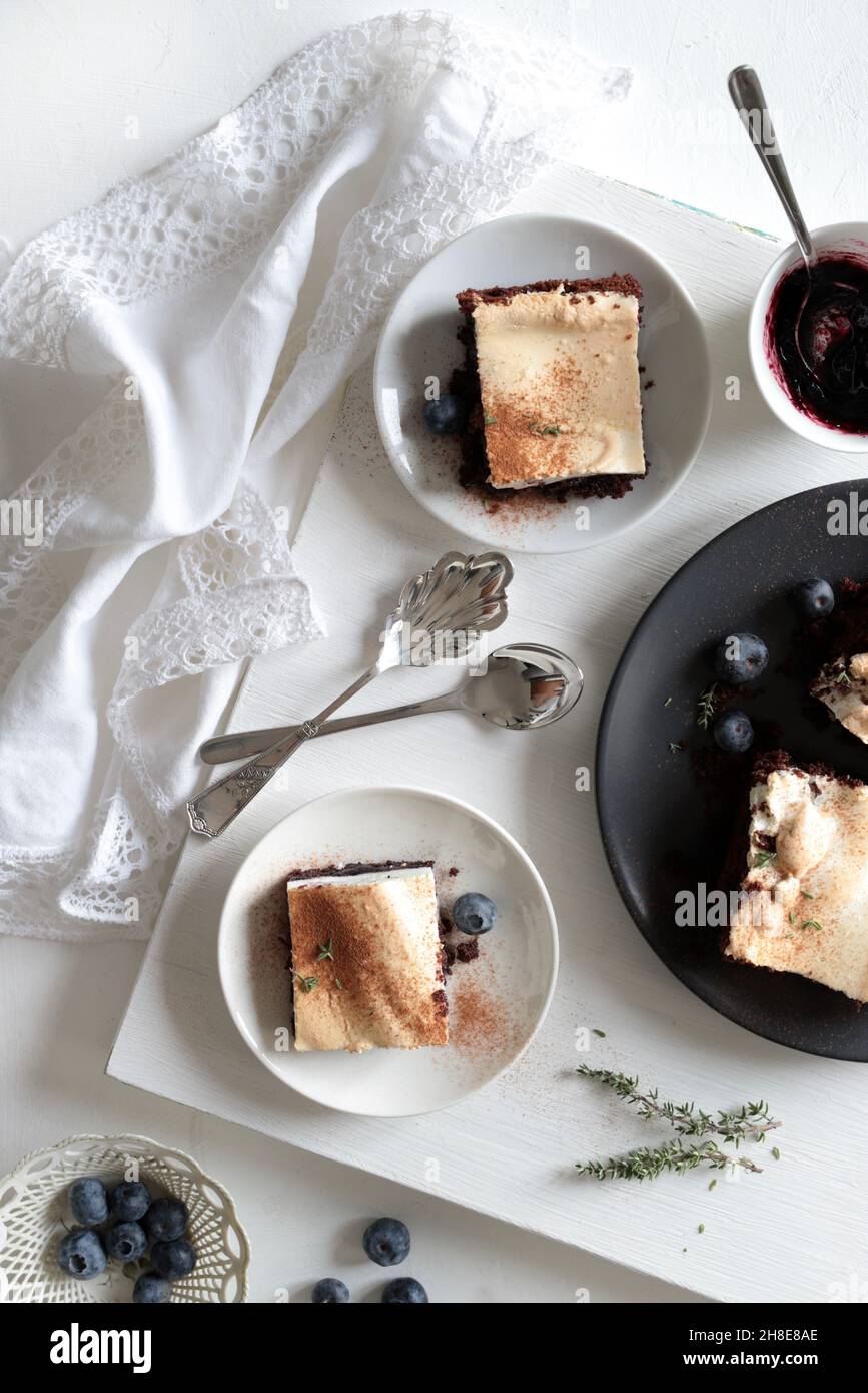 Köstlicher Kuchen mit schwarzer und weißer Schicht und Heidelbeermarmelade auf weißem Hintergrund. Weihnachten und Feiertage. Stockfoto