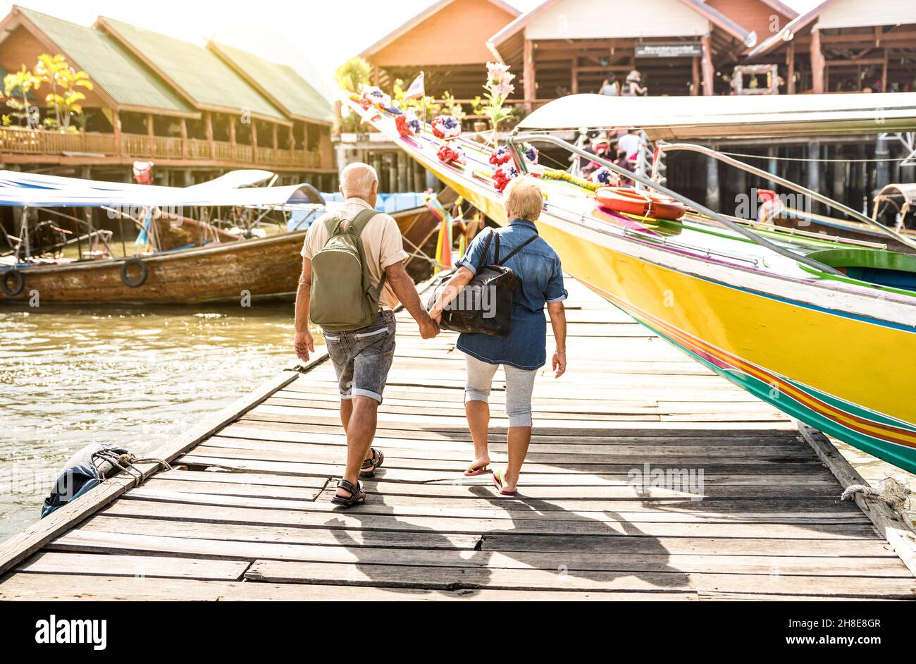 Glückliches Seniorenpaar, das im schwimmenden muslimischen Dorf Koh Panyi Hand hält - Aktives Senioren- und Reise-Lifestyle-Konzept mit älteren Menschen im Ruhestand Stockfoto