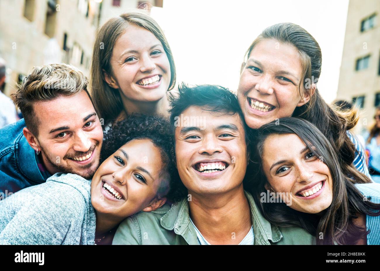 Multikulturelle Männer und Frauen, die Selfie mit Hintergrundbeleuchtung aufnehmen - Happy Milenial Life Style Konzept für junge multirassische Freunde, die einen lustigen Tag haben Stockfoto