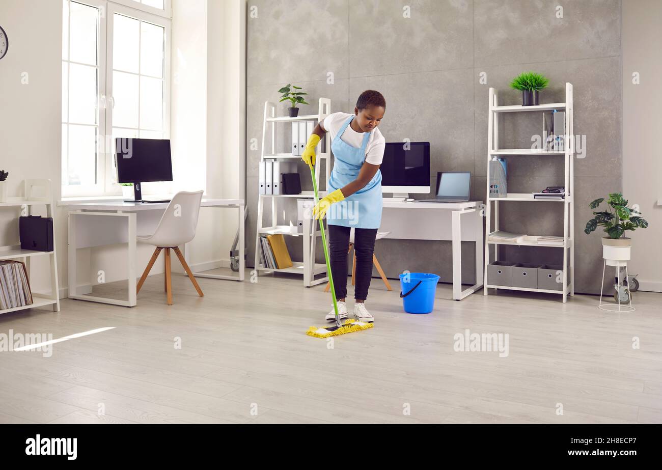 Schwarze Hausmeisterin sauberer Boden im Bürobereich Stockfoto