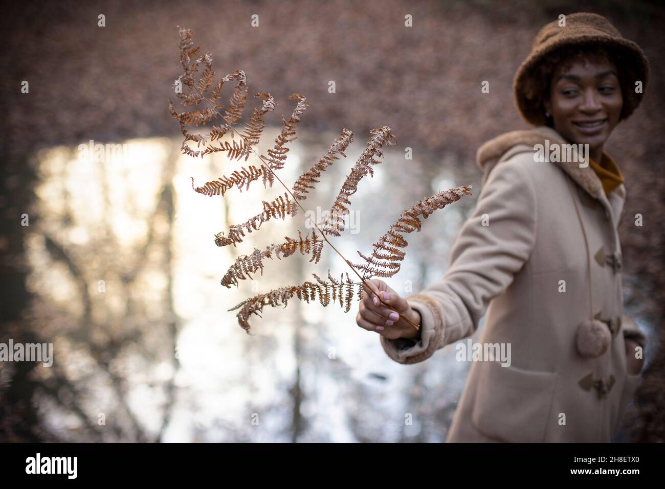 Junge Frau hält Herbstzweig im Park Stockfoto