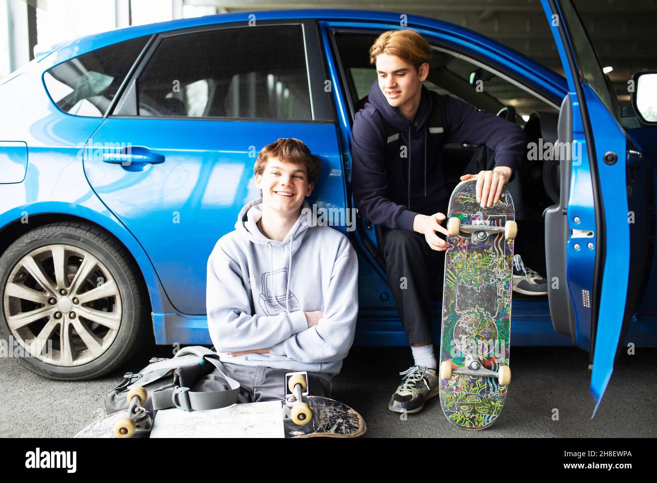 Portrait glückliche Teenager mit Skateboards im Auto Stockfoto