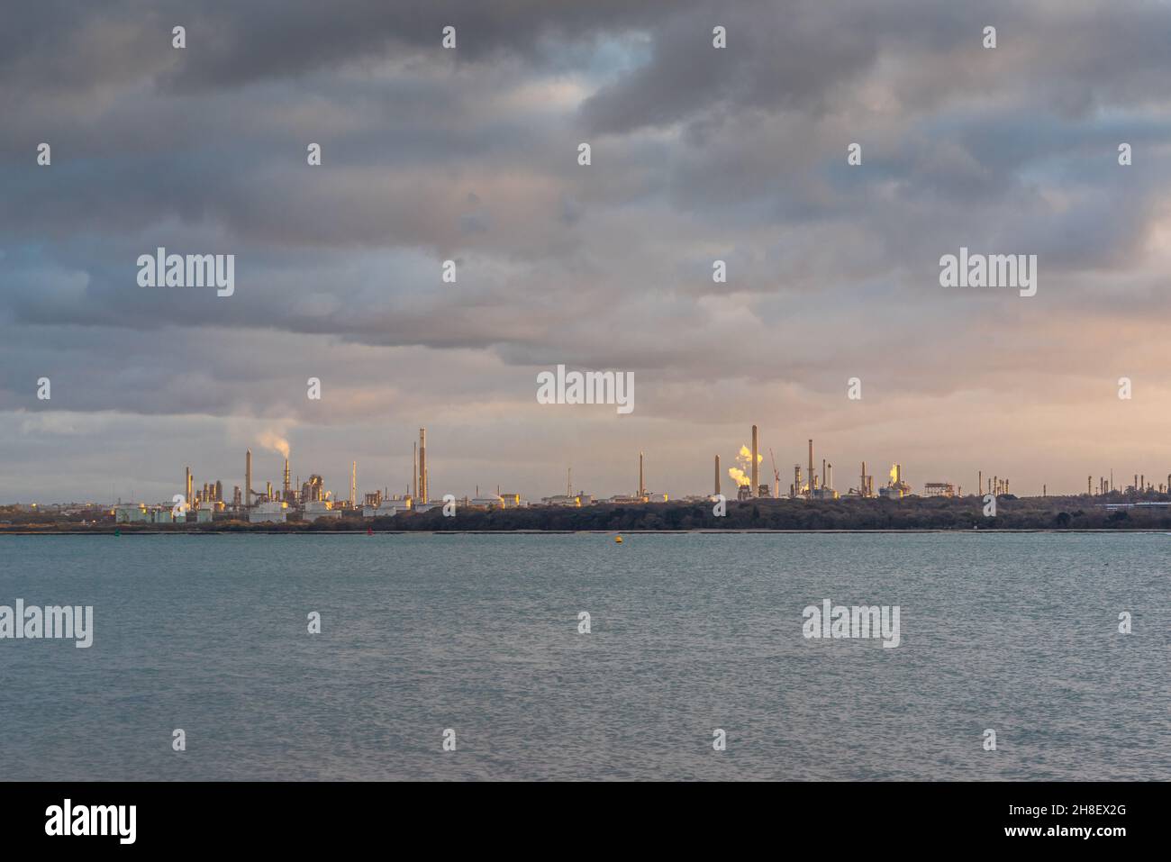 Fawley Ölraffinerie während des Sonnenuntergangs von Netley, Southampton, Hampshire, England, Großbritannien aus gesehen Stockfoto