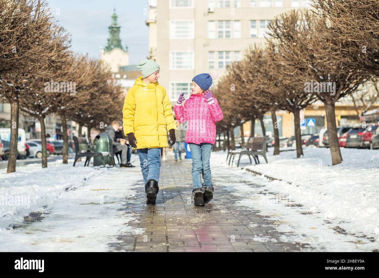 Wintersaison. Wunderschöne Stadt. Eine glückliche Familie. Fröhliche kleine Schwestern. Stockfoto