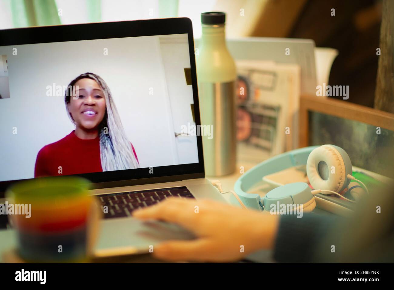 Lächelnde Geschäftsfrau auf dem Laptop-Bildschirm, chattet mit einem Kollegen Stockfoto