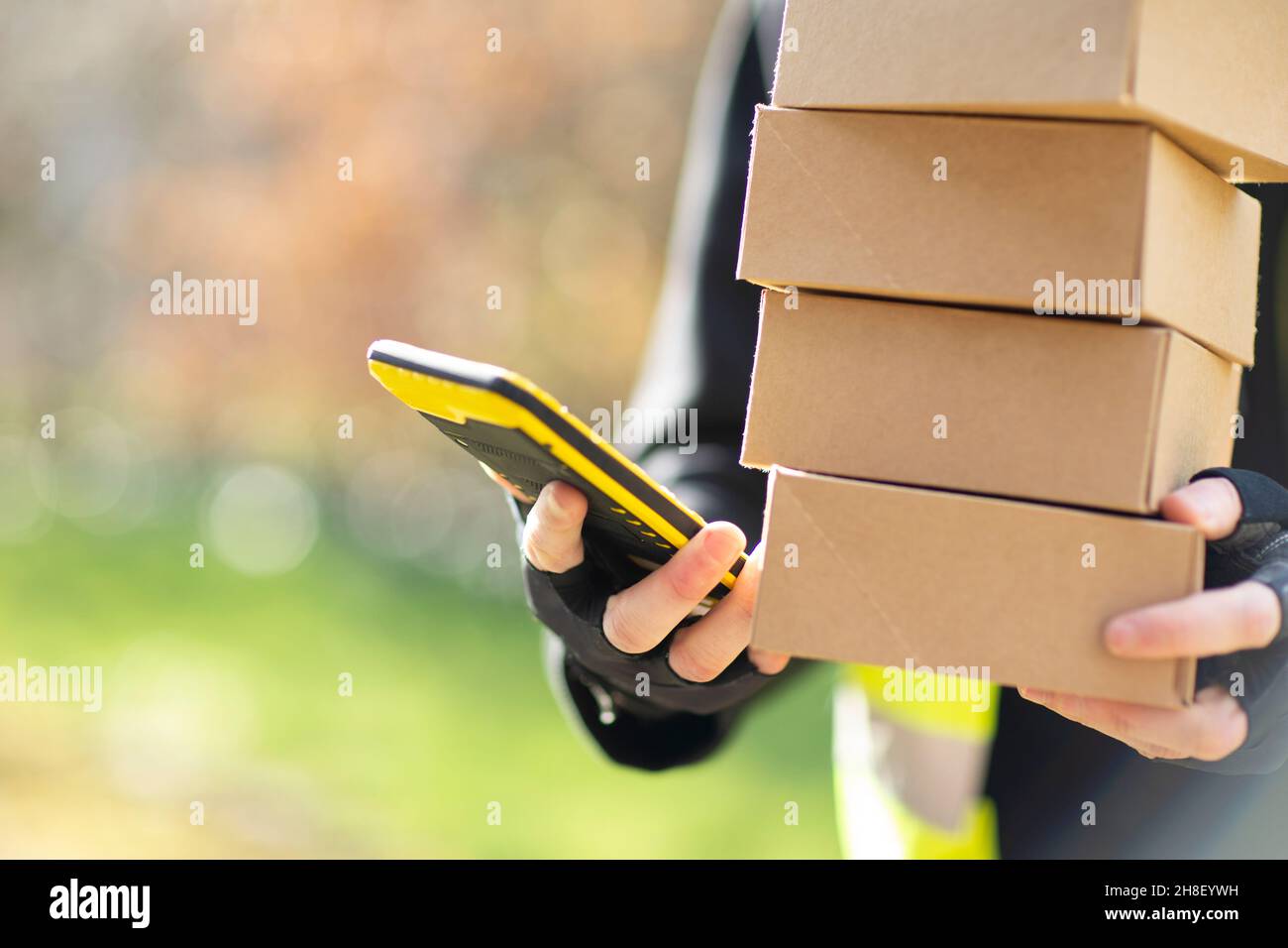 Nahaufnahme Kurier mit Smartphone liefert Pakete Stockfoto