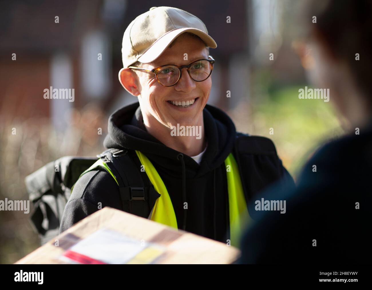 Freundlicher männlicher Kurier, der das Paket liefert Stockfoto