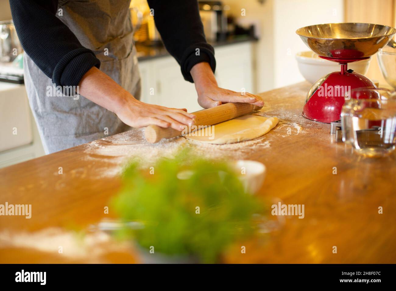 Mann rollt Teig in der Küche aus Stockfoto