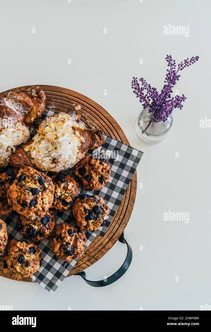 Stillleben Muffins und Croissants auf Tablett auf weißem Hintergrund Stockfoto