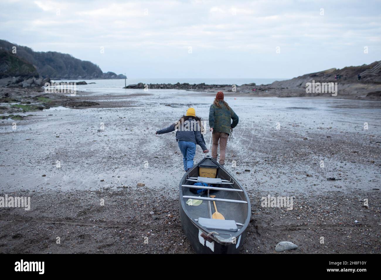 Paar ziehen Kanu am Strand Stockfoto