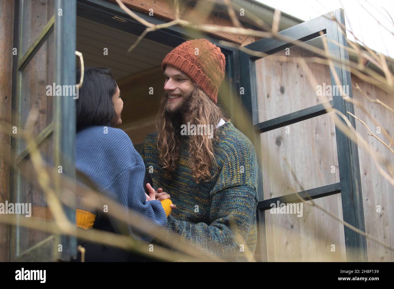 Glückliches junges Paar, das sich im Fenster der Hütte unterhielt Stockfoto
