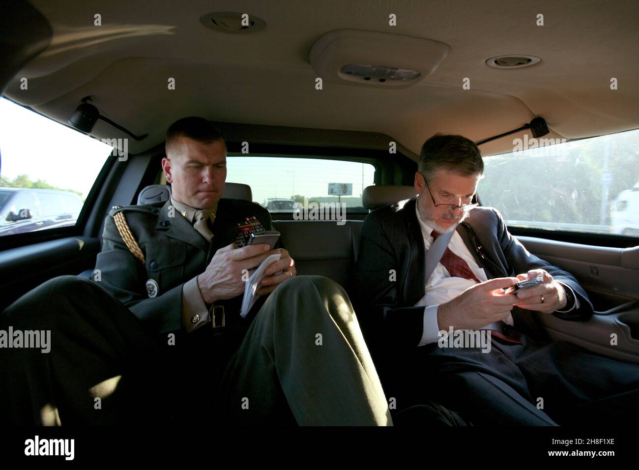 US Vice Presidential Military Aide Tim Stefanick, links, und Beratung des Vizepräsidenten, David Addington Typ auf ihre Blackberry-Handys, während in einer Limousine fahren 4. September 2008 in Kiew, Ukraine. Stockfoto