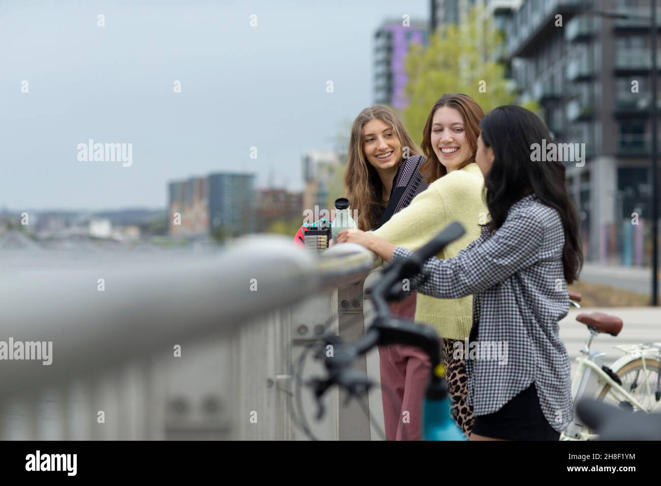 Glückliche junge Freundinnen am Geländer der Stadt Stockfoto