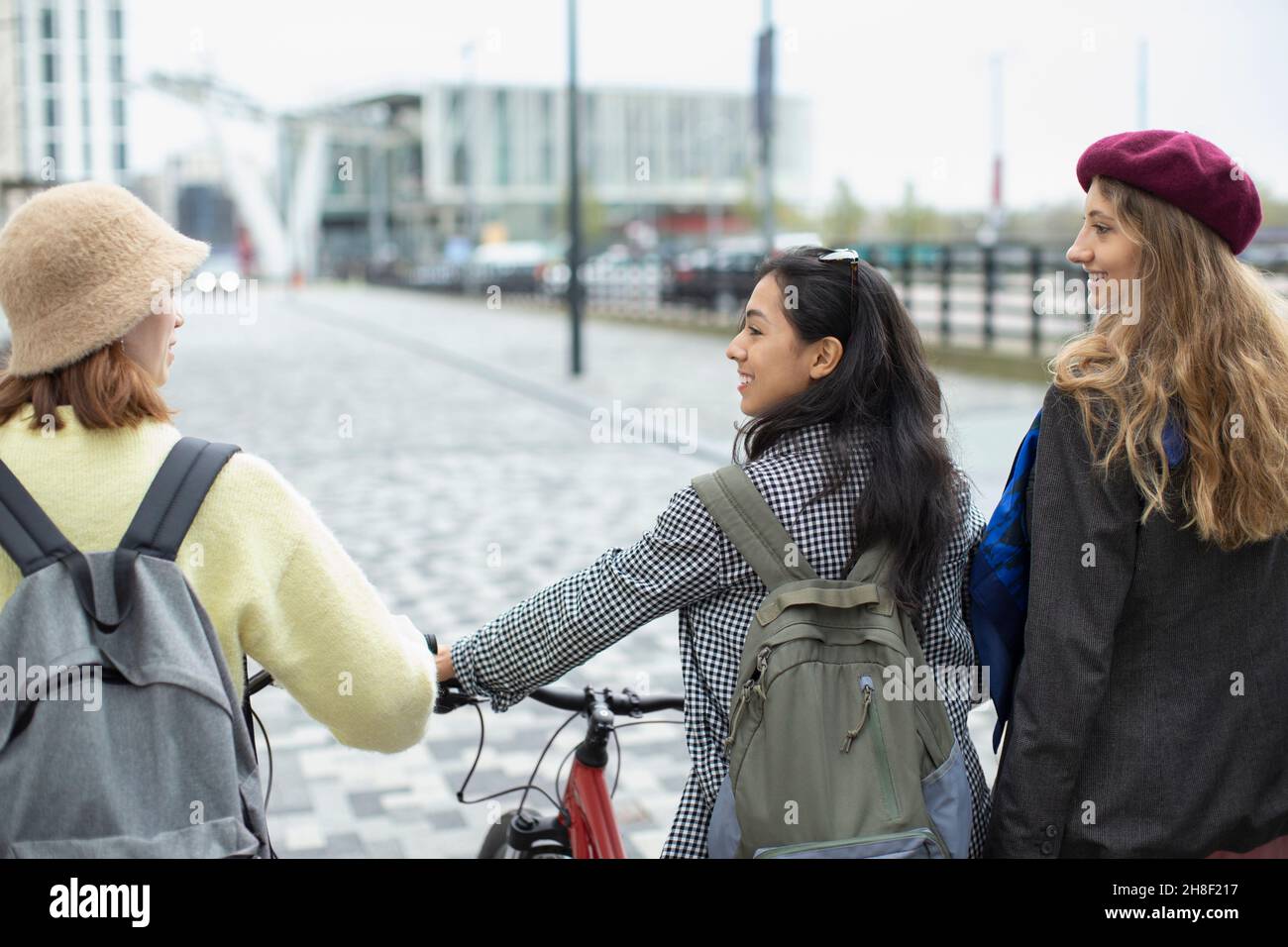 Junge Frauen befreundet sich mit dem Fahrrad auf dem städtischen Bürgersteig Stockfoto