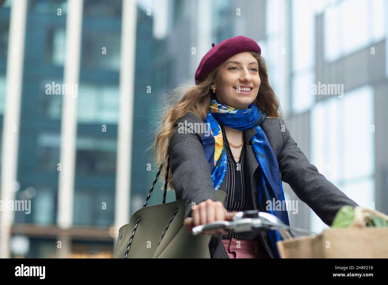 Glückliche junge Frau in Baskenmütze Fahrrad fahren Stockfoto