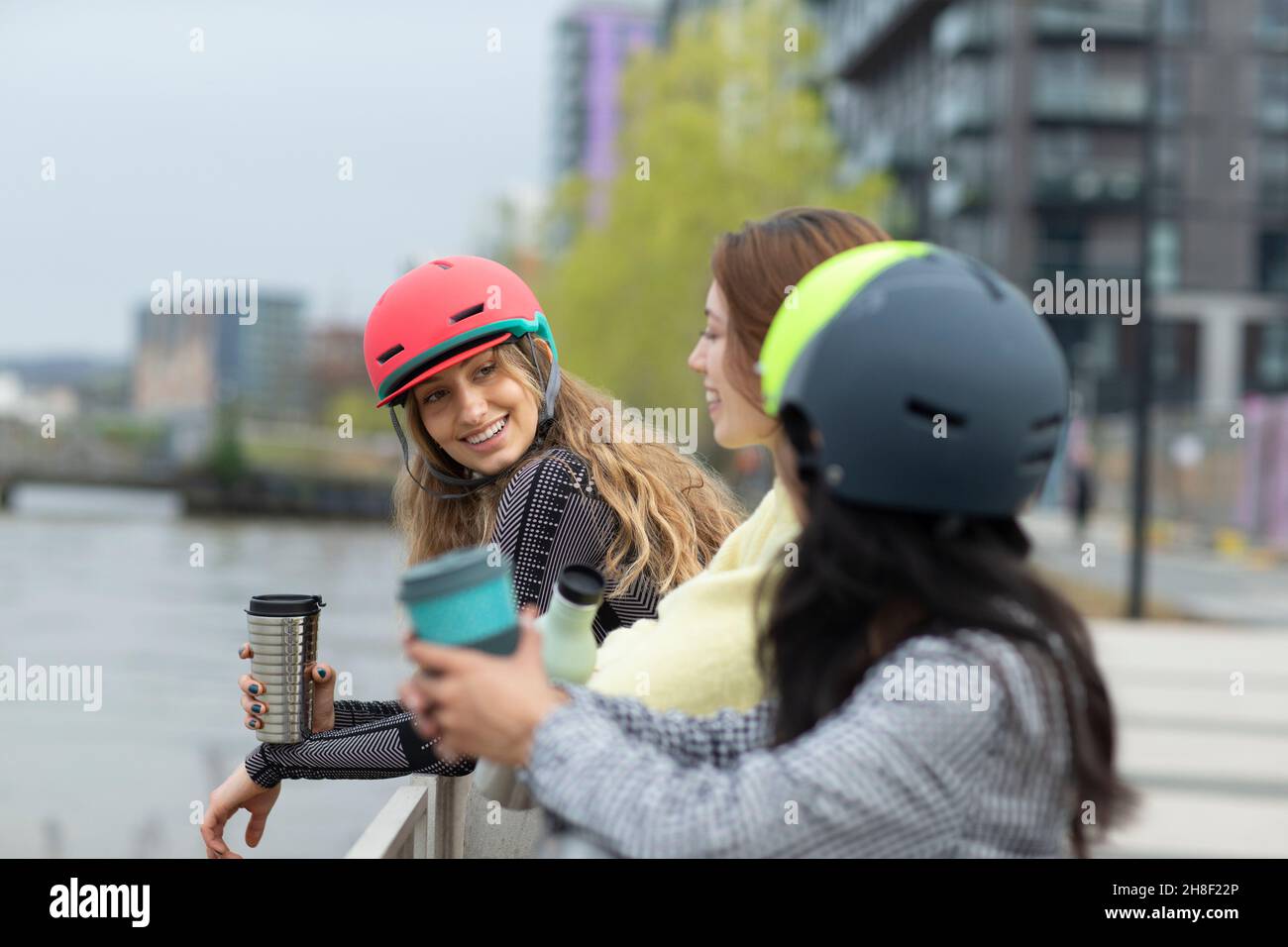 Junge Frauen, die sich mit Kaffee in der Stadt unterhalten Stockfoto