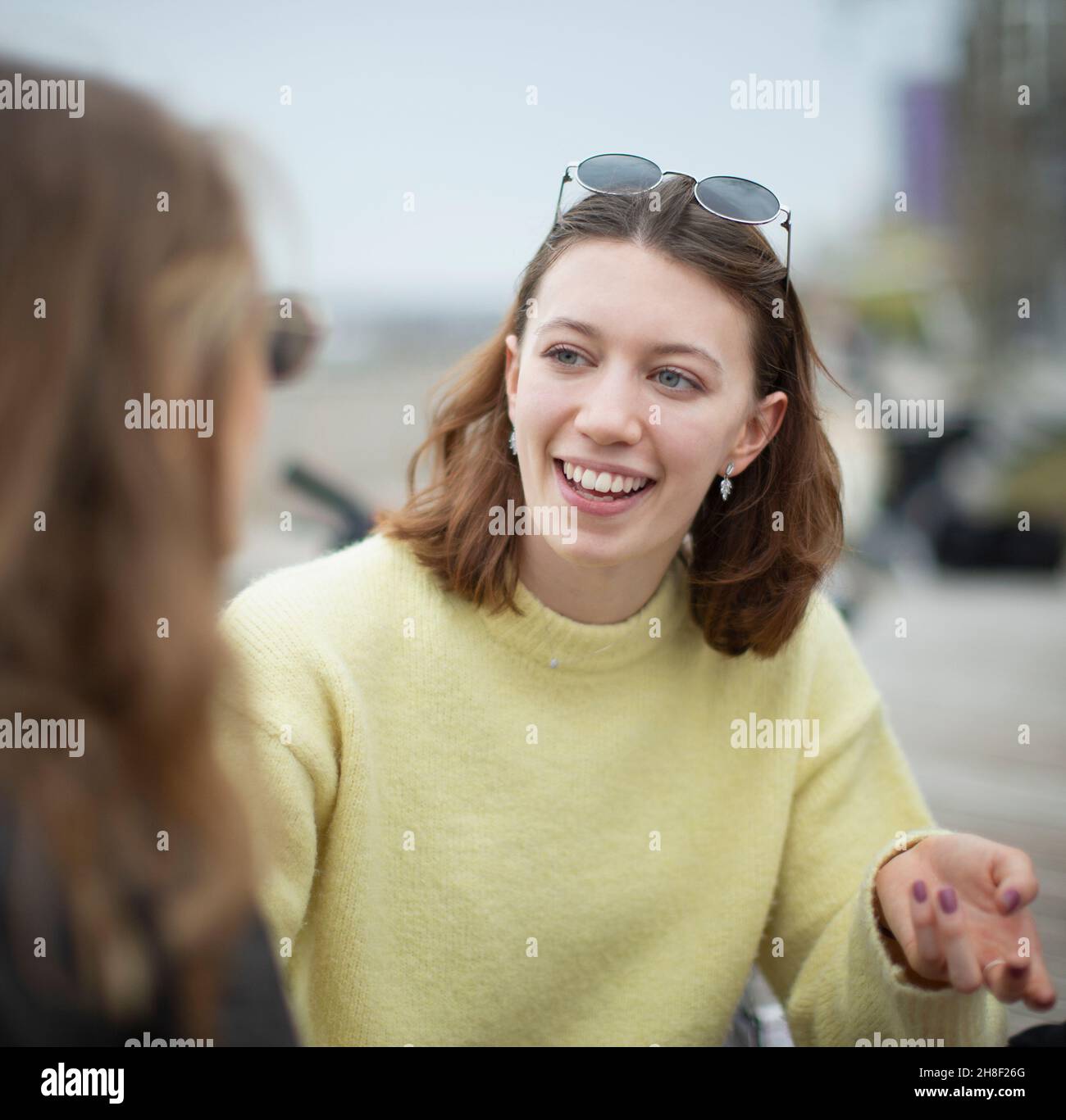 Glückliche junge Frau im Gespräch mit einem Freund Stockfoto