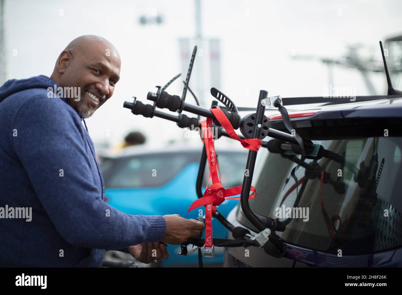 Portrait glücklicher Mann am Fahrradträger im Auto Stockfoto