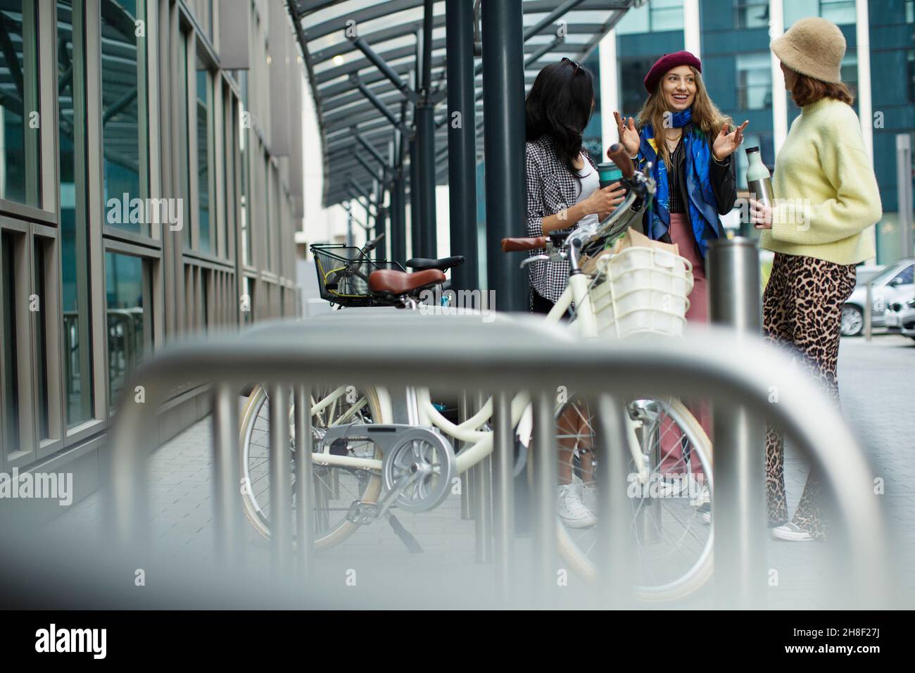 Junge Freundinnen unterhalten sich am Fahrradständer in der Stadt Stockfoto