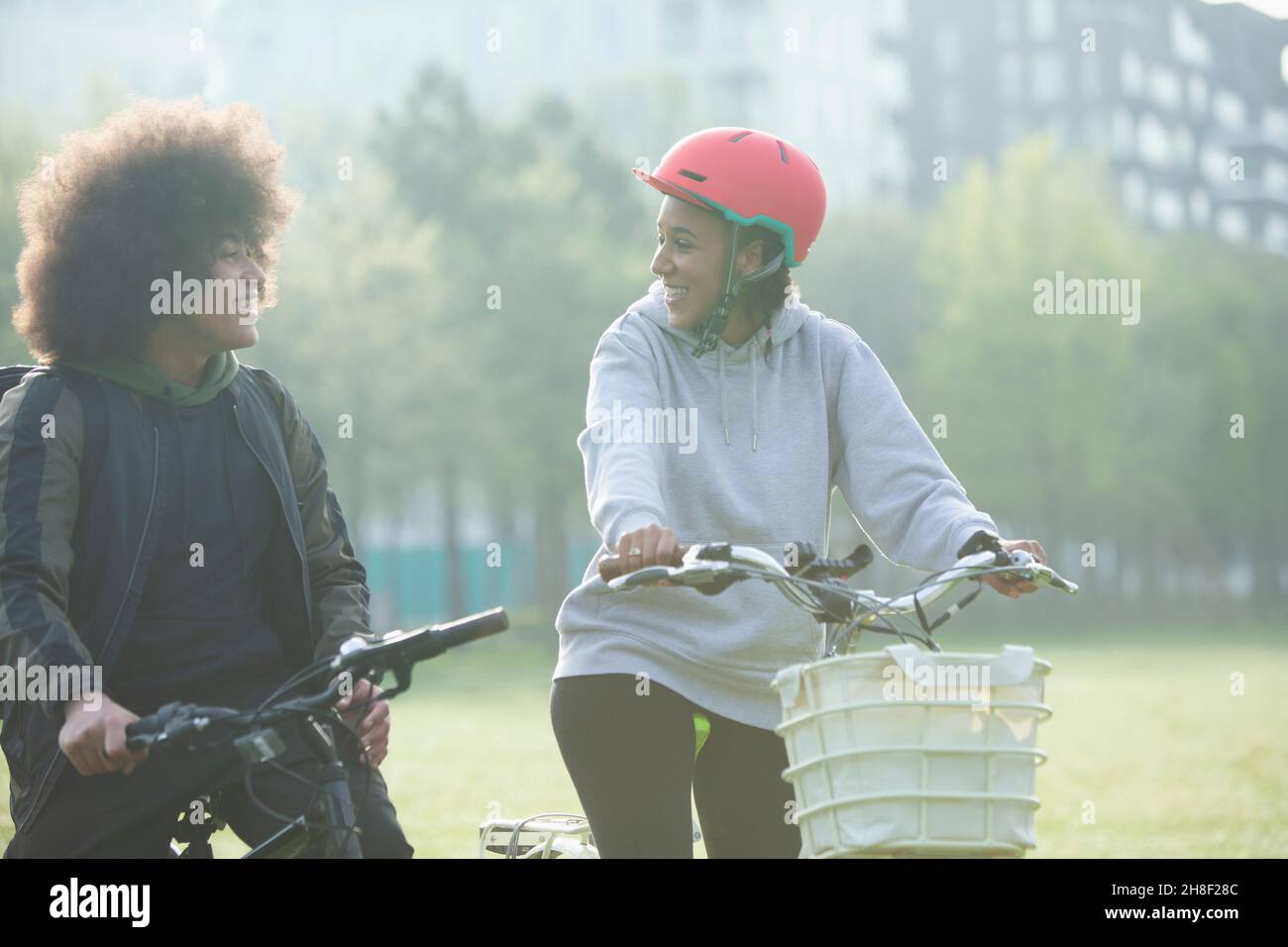 Glücklicher Zwillingsbruder und Schwester, die im Park Fahrräder reiten Stockfoto