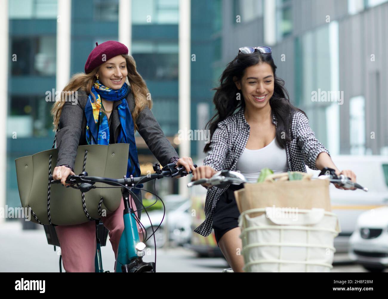 Glückliche junge Frauen Freunde Fahrrad fahren in der Stadt Stockfoto