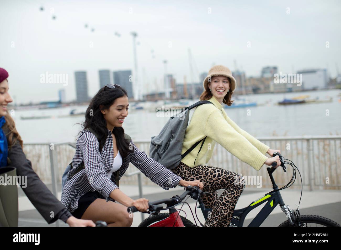Glückliche junge Frauen Freunde Fahrrad fahren in der Stadt Stockfoto