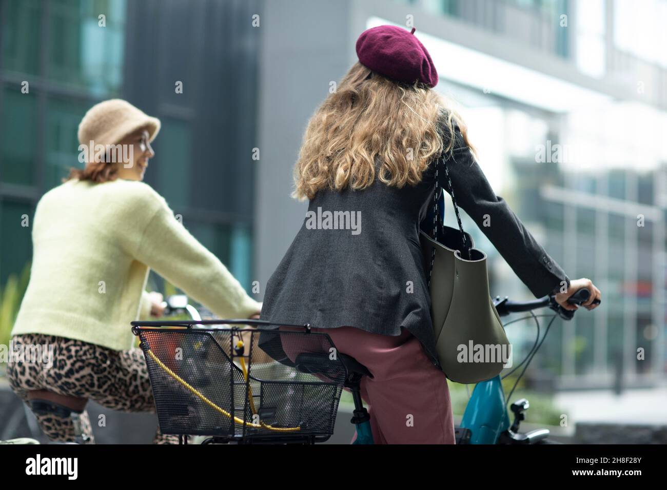 Stilvolle junge Frauen Freunde Fahrrad fahren in der Stadt Stockfoto