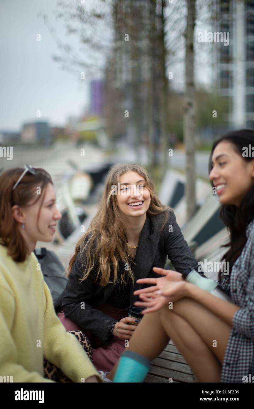 Glückliche junge Freundinnen im Gespräch in der Stadt Stockfoto
