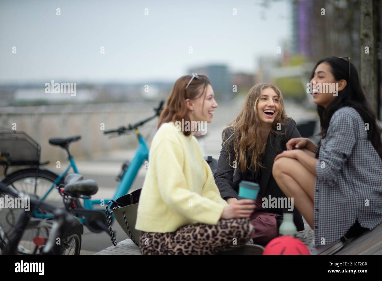 Glückliche junge Freundinnen, die in der Stadt lachen Stockfoto
