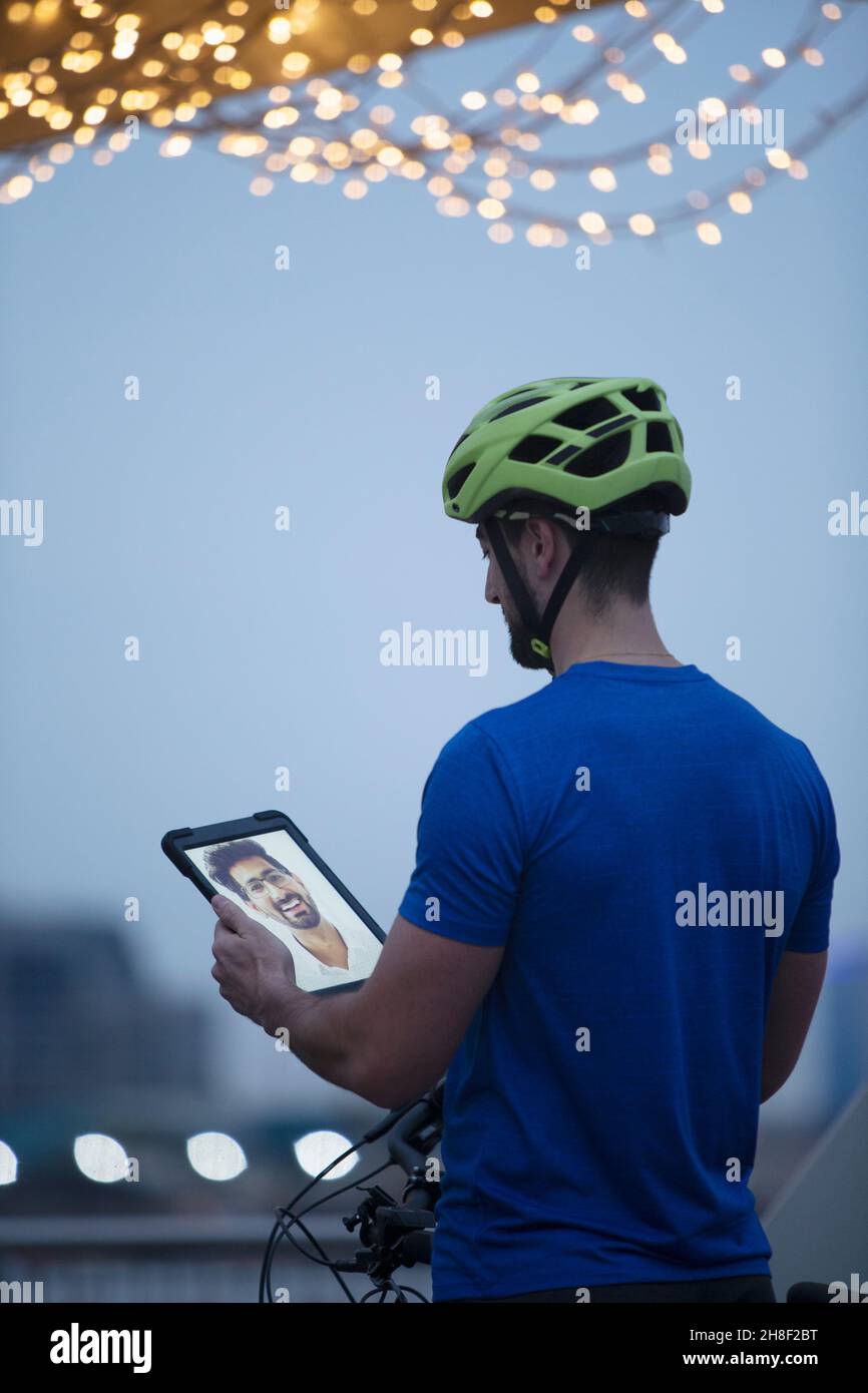 Mann in Fahrradhelm Video Chat mit Freund auf digitalen Tablet-Bildschirm Stockfoto