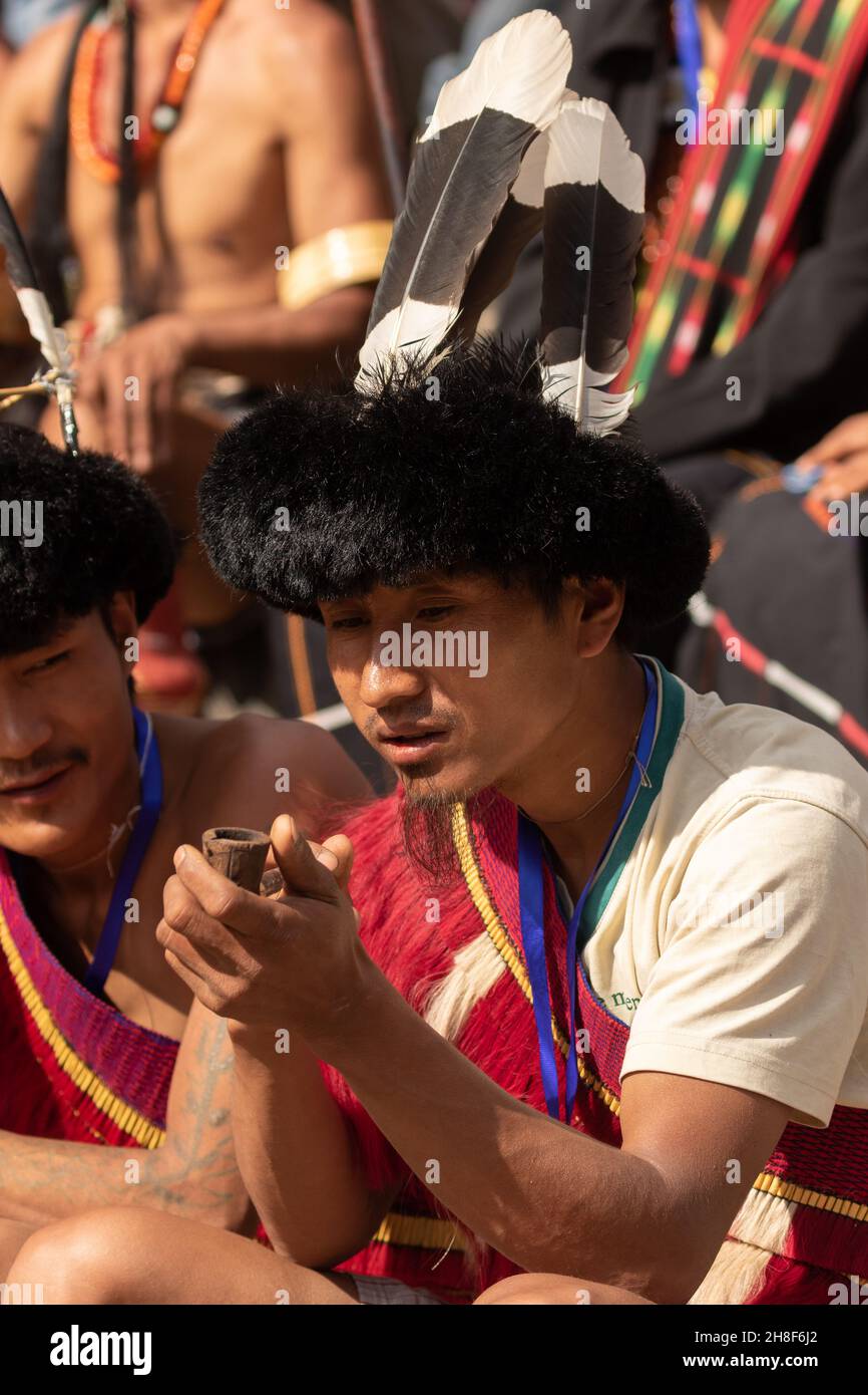 Porträt eines Stammeskleides von Naga mit einer Tabakpfeife während des Hornbill Festivals in Nagaland, Indien, am 2. Dezember 2016 Stockfoto