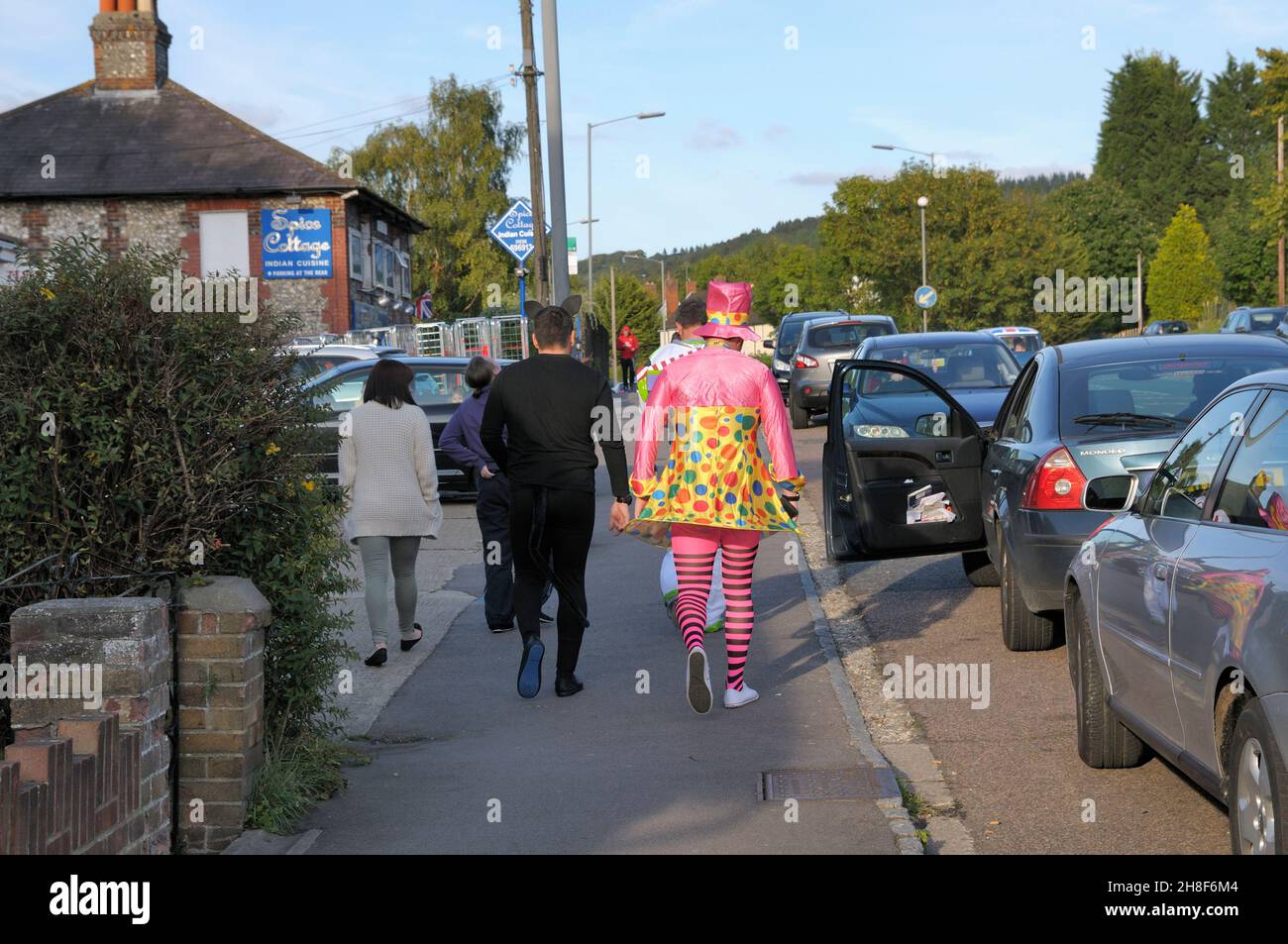Junge Männer, die auf einem Junggesellenabschied in humorvollen Kostümen eine Straße entlang gehen, Großbritannien Stockfoto