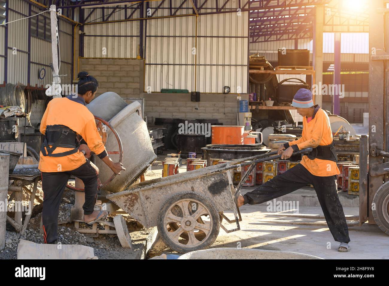 Konstruktionsdetails - Arbeiter, der Zement oder Beton mit Ziegelstein verlegt, Bauarbeiter Stockfoto