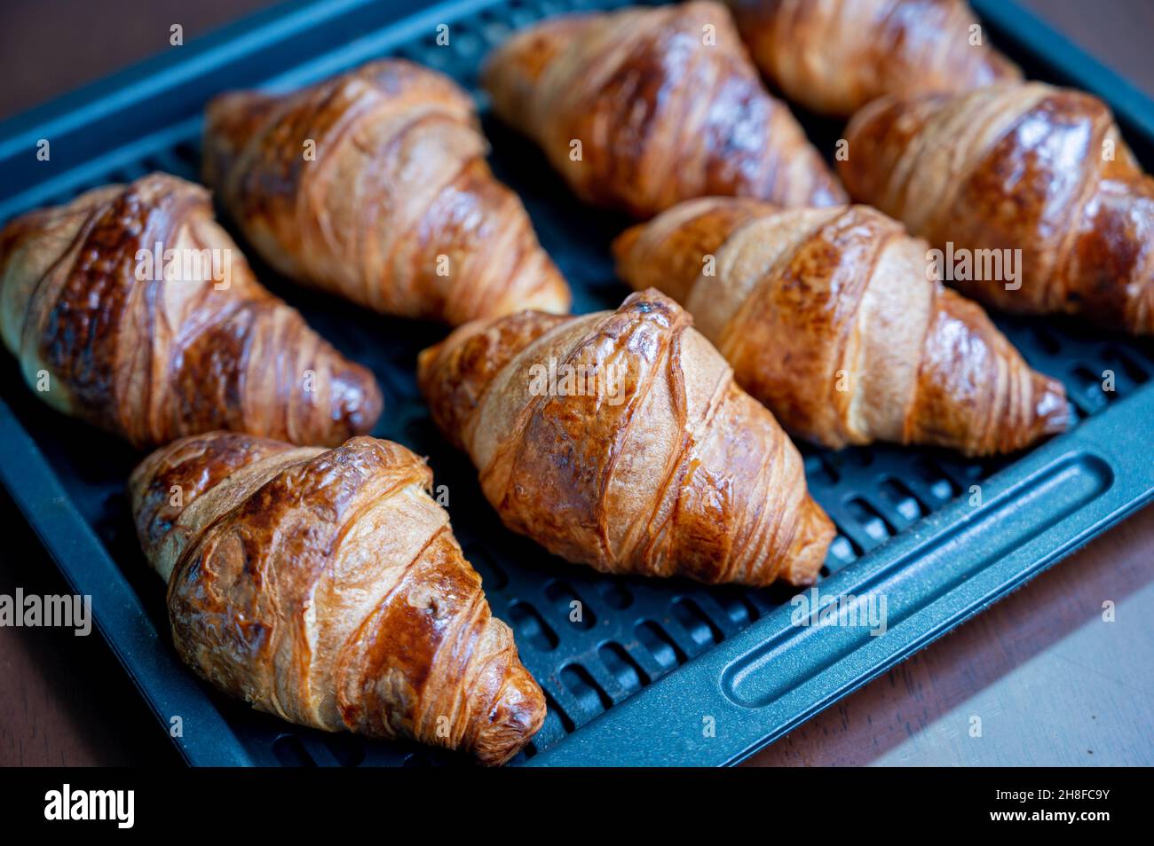 Hausgemachtes Croissant. Ein Croissant zum Frühstück, das köstlich in einem Haushaltsofen zubereitet wird. Stockfoto