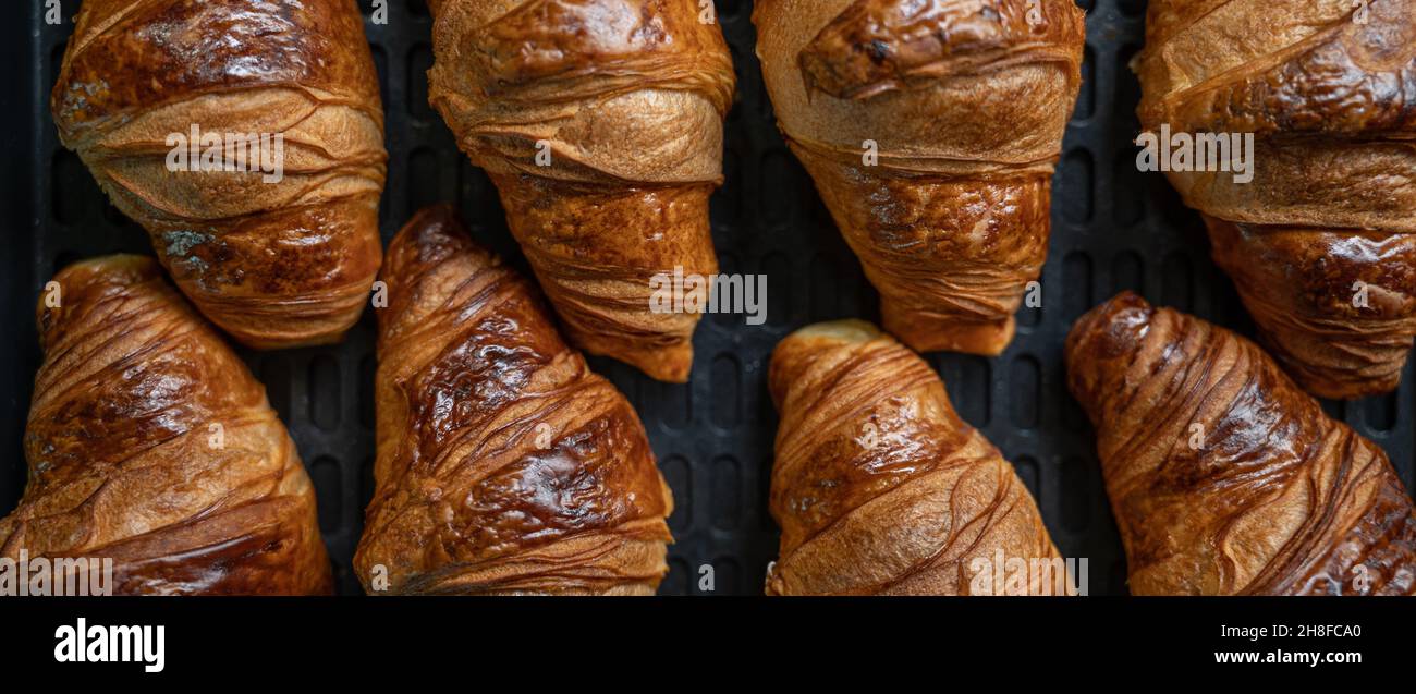 Hausgemachtes Croissant. Ein Croissant zum Frühstück, das köstlich in einem Haushaltsofen zubereitet wird. Stockfoto