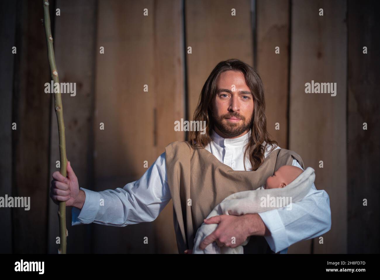 Biblischer Charakter von Joseph, der das Jesuskind in einer Krippe hält Stockfoto