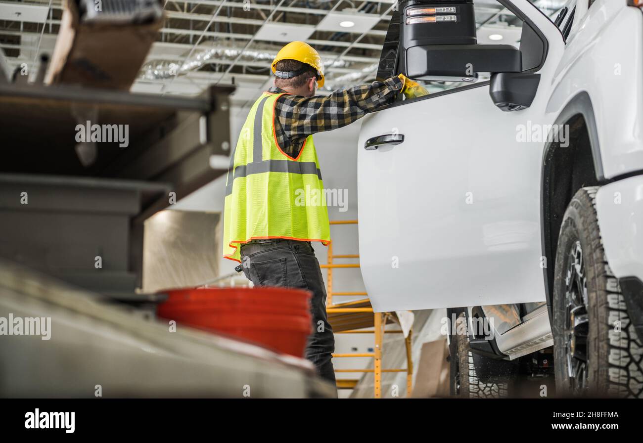Industriedesign. Kaukasischer Bauarbeiter mit Harthut und seinem modernen Pickup Truck im neu entwickelten Geschäftsgebäude Stockfoto