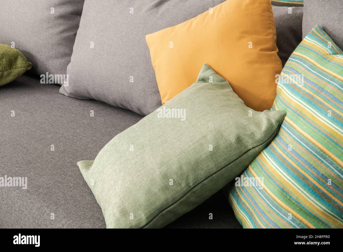 Ein paar elegante und dekorative Kissen auf einem Schlafsofa in einem Zimmer. Nahaufnahme Des Fotos. Stockfoto