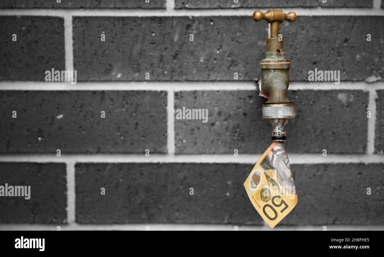 Ein Messing-Wasserhahn oder Wasserhahn mit einer 50-Dollar-Note, die wie Wasser aus ihm herauskommt. Schwarz-weiße Backsteinmauer Hintergrund. Stockfoto