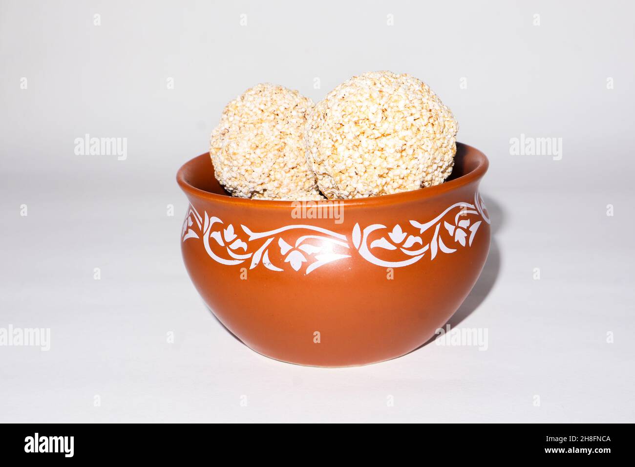 Indische Süßigkeit für traditionelles Festival makar sankranti :Rajgira laddu aus Amaranth Samen in Schale auf weißem Hintergrund Stockfoto