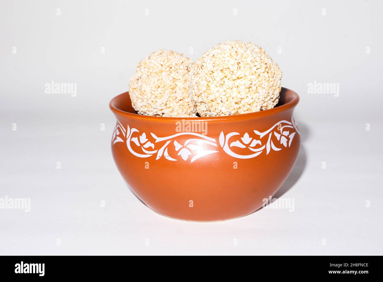 Indische Süßigkeit für traditionelles Festival makar sankranti :Rajgira laddu aus Amaranth Samen in Schale auf weißem Hintergrund Stockfoto